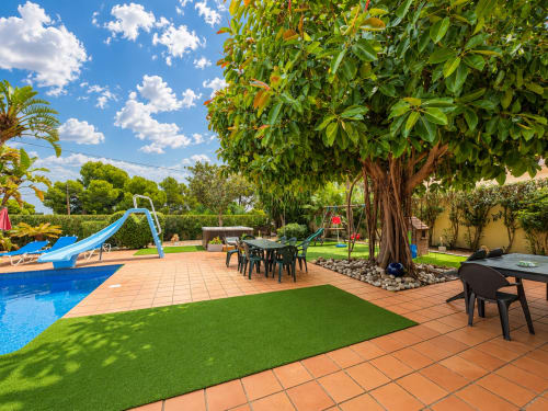 Casa Emilia villa in Moraira with private pool, lounge area, large tree, and terracotta patio under blue sky