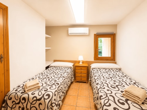 Twin bedroom with patterned bedspreads and wooden furnishings at Casa Emilia villa in Moraira, Spain