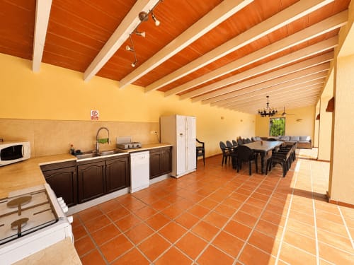 Spacious open-plan kitchen and dining area at Casa Emilia villa in Moraira with wooden beams, terracotta tiles