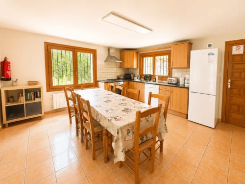 Spacious kitchen-dining area in Casa Emilia villa, Moraira with wooden cabinets, table seating, and modern appliances