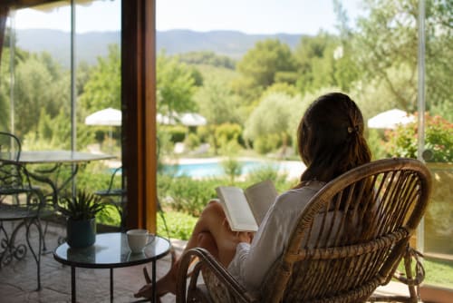 Woman reading by pool at Country House Bosco d'Olmi, Sant'Andrea del Garigliano, with scenic hillside views