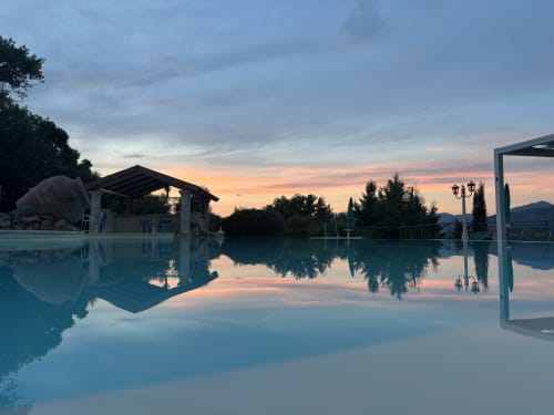 Serene sunset at Country House Bosco d'Olmi pool in Sant'Andrea del Garigliano, Italy, with mountain views.