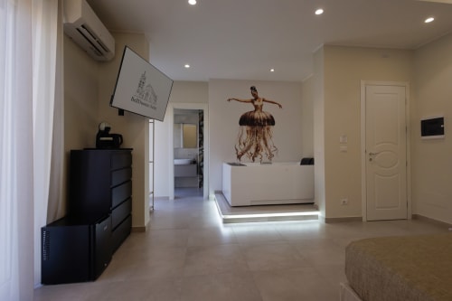 Moderna hall dell'hotel BellDuomo Suite Messina con reception bianca, opere di balletto e interni eleganti in tonalità beige