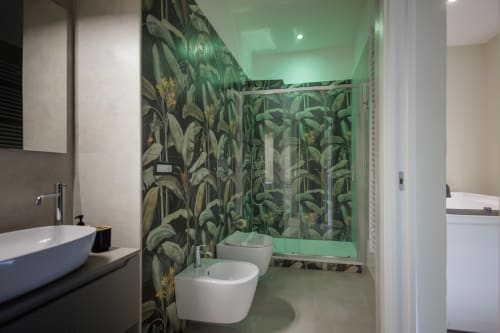 Bagno moderno della BellDuomo Suite Messina con piastrelle verdi tropicali, sanitari bianchi e box doccia in vetro