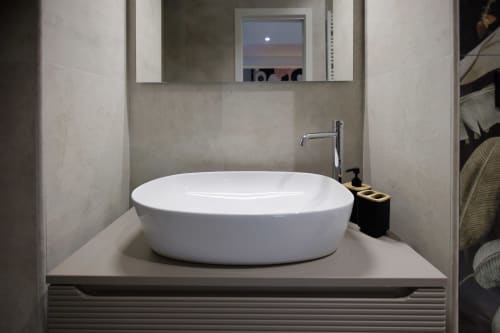 Lavabo ovale bianco moderno nella suite BellDuomo Messina con specchio con vista città e design minimalista