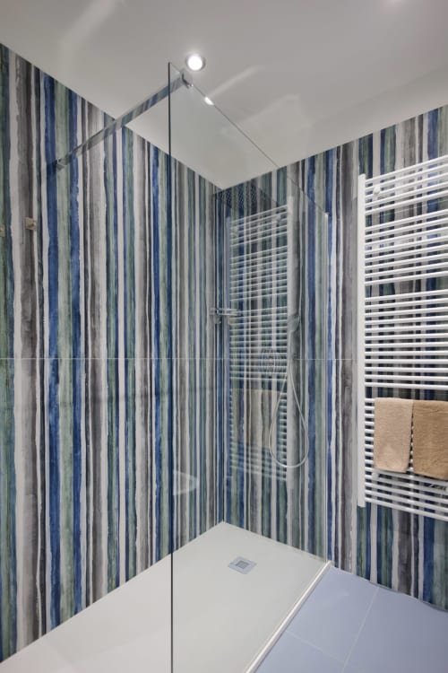 Moderno bagno con doccia a piastrelle blu righe alla BellDuomo Suite Messina, con box doccia in vetro e scaldasalviette