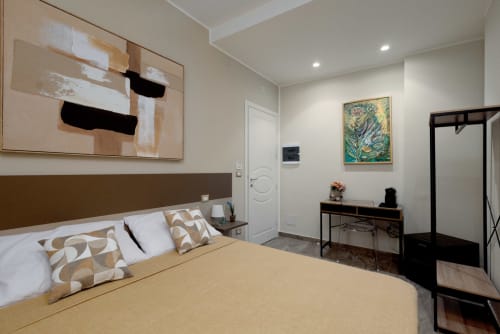 Camera moderna BellDuomo Suite Messina con letto matrimoniale, biancheria beige, quadri astratti, scrivania e vista sulla città