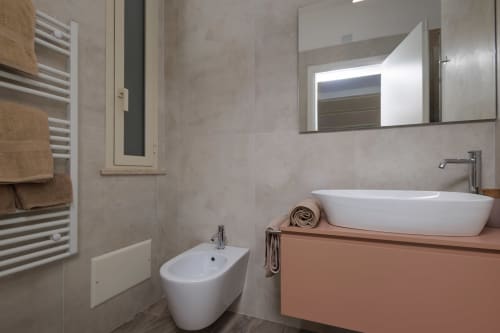 Bagno moderno della BellDuomo Suite Messina con lavabo bianco, bidet, specchio illuminato, scaldasalviette e