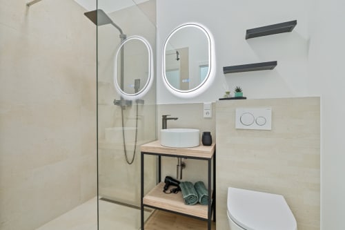 Salle de bain moderne de Mattbnb Ankoni Stay 3.2 à Metz avec miroirs LED doubles, vasque, douche vitrée et meuble noir