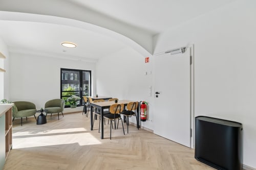 Chambre moderne Mattbnb Metz avec table à manger, chaises vertes, vue sur la ville et mobilier contemporain