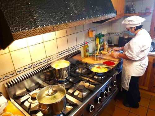 Chef cocinando en la cocina de la casa rural de L'Orri Rectoria Nova, refugio de montaña en Campelles