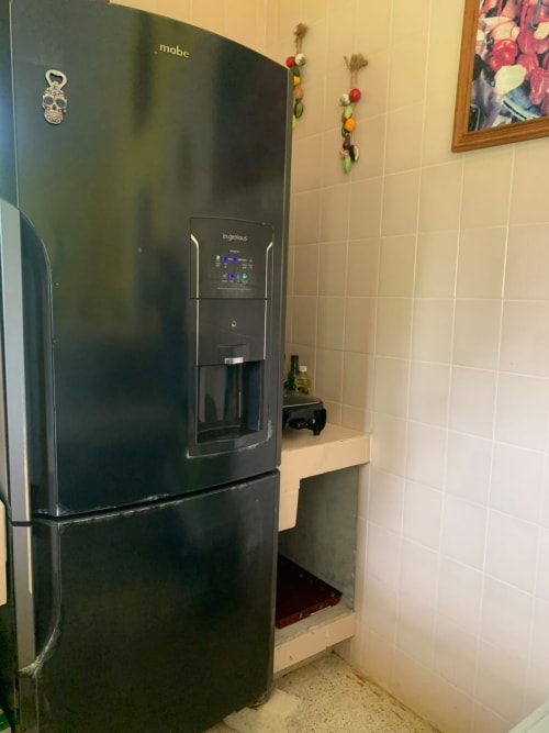 Refrigerador negro Mabe con dispensador de agua en la cocina de la villa Casa Leticia en La Morada, Monte Gordo