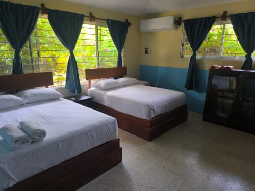 Amplio dormitorio de villa en La Morada con dos camas, vistas al jardín, cortinas oscuras y aire acondicionado en Monte