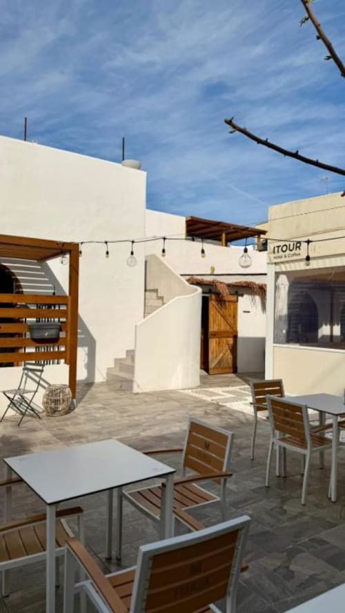 Terraza exterior del Hotel & Coffee ITOUR en Museros con mobiliario moderno, arquitectura blanca y cielo azul despejado