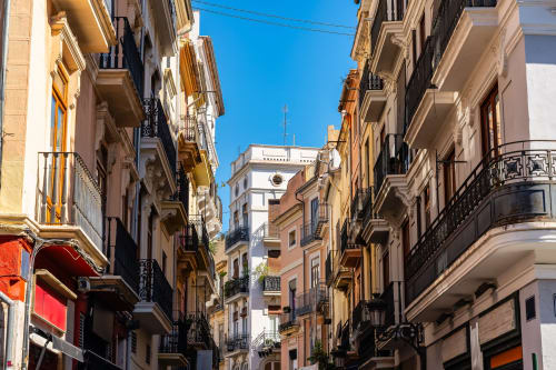 Calle histórica de Museros con edificios coloridos y cielo azul despejado, ubicación del Hotel ITOUR