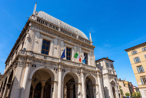 Historic palazzo in Brescia displaying Italian flags, Casa Città bed and breakfast entrance