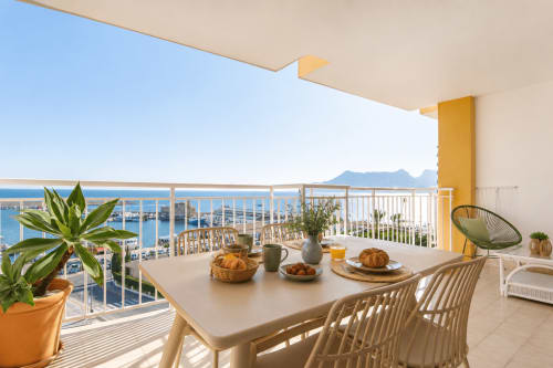 Balcón con vista al mar en Riurau Home, Calpe con mesa de comedor, plantas en macetas y vistas de la costa mediterránea