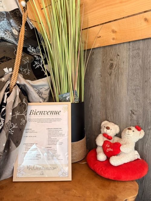 Panier de bienvenue aux Cabanes des Marchous avec plante verte, lettre d'accueil française et oursons rouges décorés