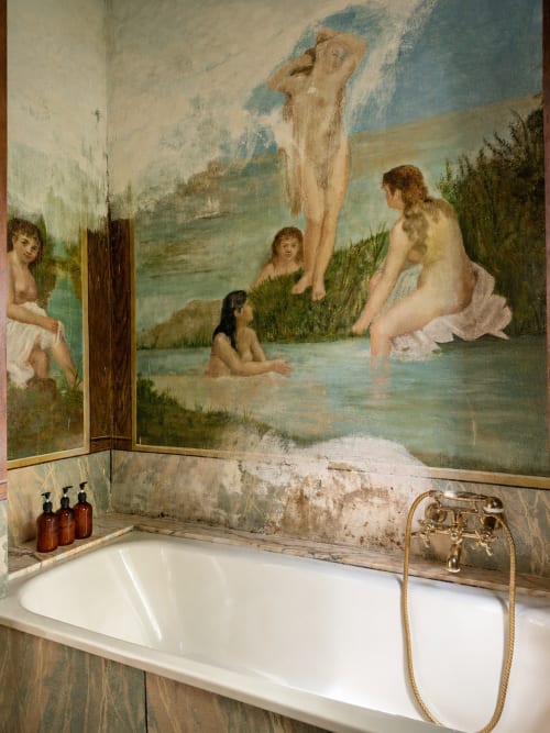 Vintage bathroom at Veneto Villa with classical frescoed wall art overlooking lake, white soaking tub with brass fixtures and