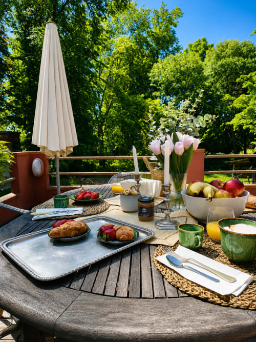 Elegant outdoor breakfast setup at Veneto Villa with pink tulips, pastries, fresh fruit, and garden views in Sant'Agostino,