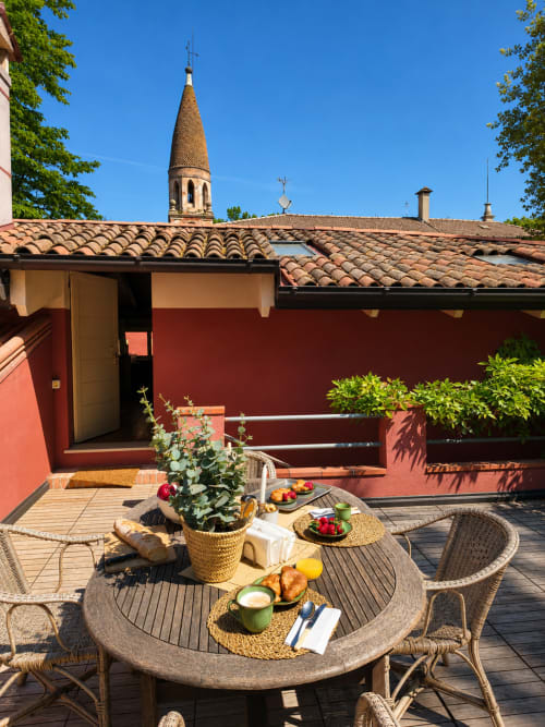 Garden Loft terrace at Veneto Villa with dining table, fresh fruits, and tower view in Sant'Agostino