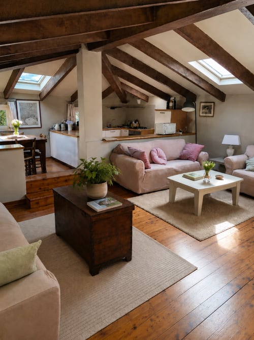 Cozy loft apartment at Veneto Villa with exposed beams, beige sofa, wooden beams, skylight, and open kitchen