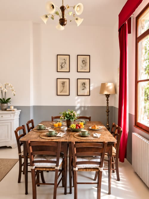 Elegant dining room in Wisteria Lodge at Veneto Villa with wooden table, set for breakfast with tea and fresh fruit, garden