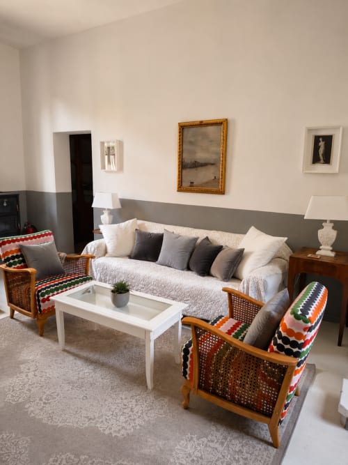 Elegant living room at Veneto Villa with cream sofa, wooden armchairs with colorful blankets, white coffee table, and garden
