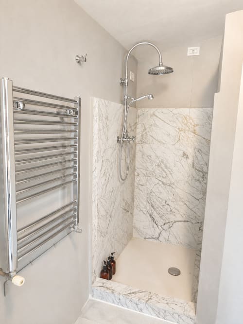 Modern shower enclosure with marble walls and overhead rainfall showerhead at Veneto Villa, Sant'Agostino