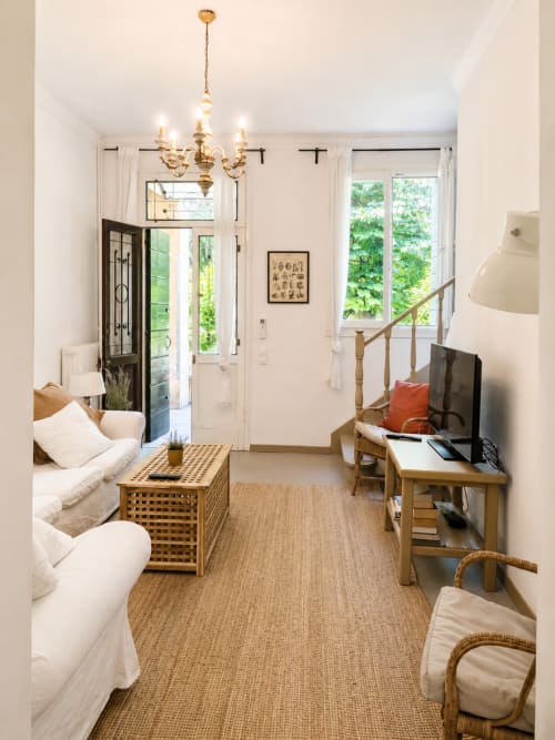 Bright Garden Lodge apartment at Veneto Villa with bed, TV area, wooden furniture, and garden views through French doors