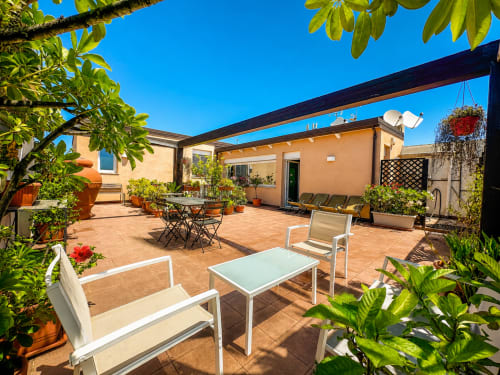 Terrazza soleggiata del B&B Pellicano a Reggio Calabria con zona lounge, area dining e piante rigogliose