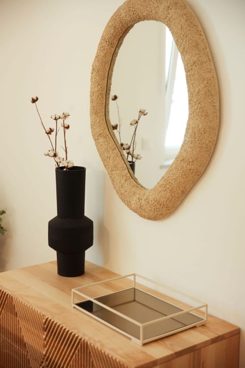 Styled wooden console table with cork round mirror, black vase with dried flowers, and tray at Sea'Ya Cascais apartment