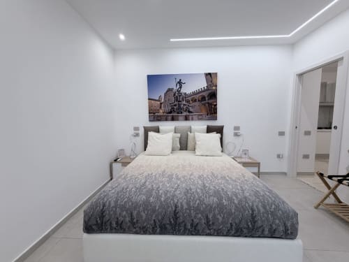 Moderna camera King Deluxe a Bologna con letto matrimoniale, opera d'arte, bagno e design minimalista