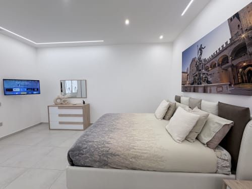 Camera da letto moderna con letto king size presso Dream Suite Bologna, TV a schermo piatto, zona living e vista sulla corte