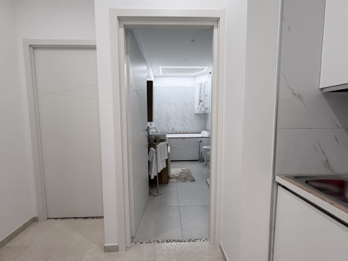 Ingresso della sala da bagno nella suite Dream dell'appartamento Bologna con pareti rivestite in marmo e finiture moderne