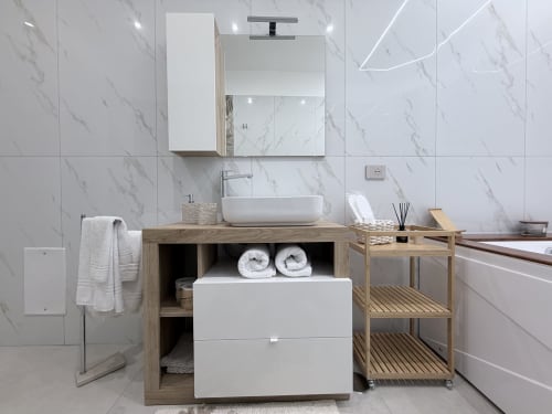 Bagno moderno della Dream Suite Bologna con piastrelle in marmo, mobile in legno, lavabo bianco a vessel e scaffali aperti con asciugamani