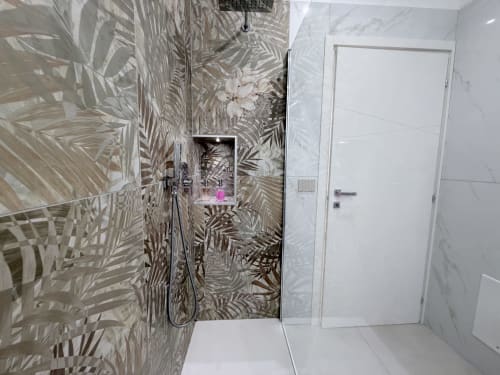 Bagno moderno della Dream Suite Bologna con piastrelle a motivo palme tropicali, cabina doccia in vetro e finiture in marmo bianco