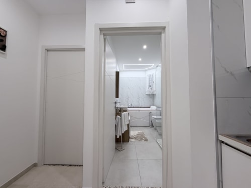 Ingresso della moderna bathroom della Dream Suite Bologna con piastrelle in marmo e finiture contemporanee visibili dall'accesso