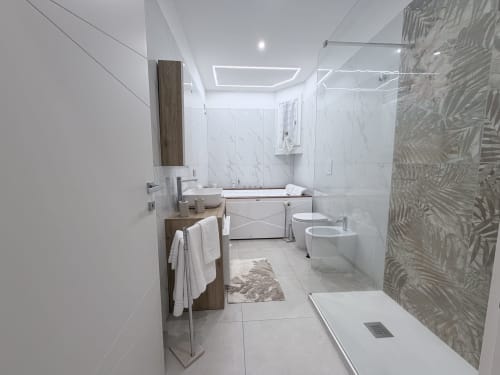 Bagno moderno nella Dream Suite Bologna con marmi bianchi, vasca idromassaggio, doccia walk-in e legno elegante