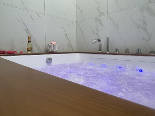 Vasca da bagno idromassaggio di lusso con illuminazione LED blu nella suite King Deluxe di Dream Suite Bologna, dotata di