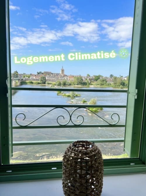 Vue depuis la fenêtre de la chaumière climatisée du Gîte La Vue Loire surplombant la Loire et le bourg de Saint-Denis-de-l'Hôtel