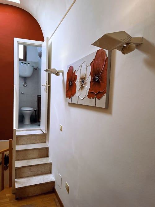 Corridoio dell'appartamento Nel Cuore di Lanciano con parete rossa, ingresso bagno e opere floreali su pareti bianche