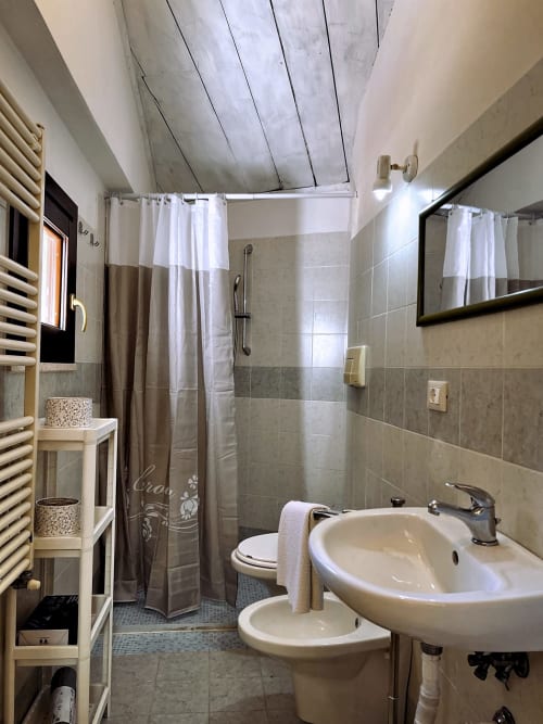 Bagno moderno nell'appartamento Nel Cuore di Lanciano con doppio lavabo, WC, doccia, scaldarpa e piastrelle bianche