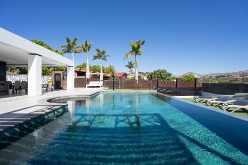 Villa moderna con piscina reluciente, palmeras y tumbonas en Home Stay Gran Canaria, Las Palmas