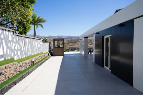 Terraza de villa moderna en Home Stay Gran Canaria con vistas a las montañas, valla blanca con patrones y arquitectura contemporánea