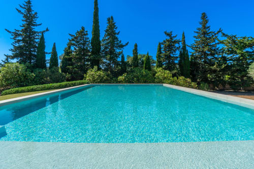 Piscina turquesa en Massa Properties de Artà con cipreses y cielo azul despejado