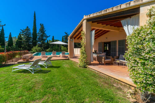 Villa de lujo en Artà con patio de barro cocido, vistas a la piscina y pérgola cubierta de hiedra con vista a jardines cuidados