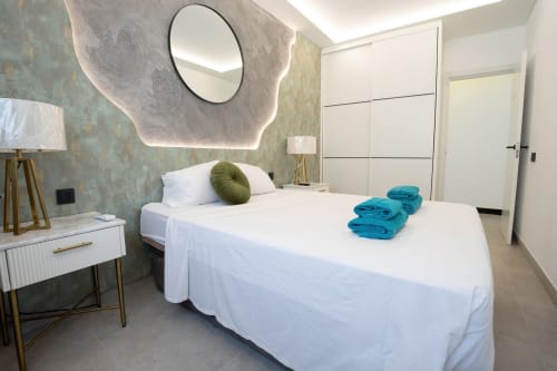 Habitación moderna en Villa La Menta, Gran Canaria con cama blanca, almohada verde y toallas turquesas