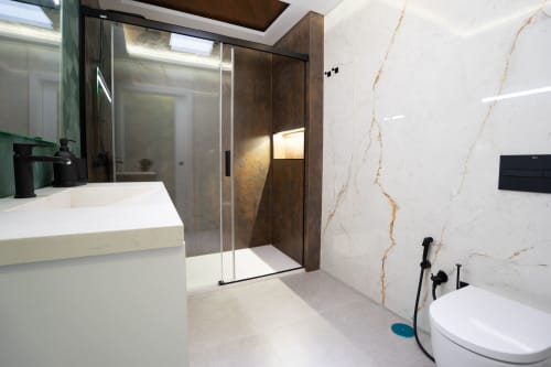 Baño moderno en Villa La Menta, Casa Rural Gran Canaria con paredes de mármol, ducha walk-in y accesorios contemporáneos