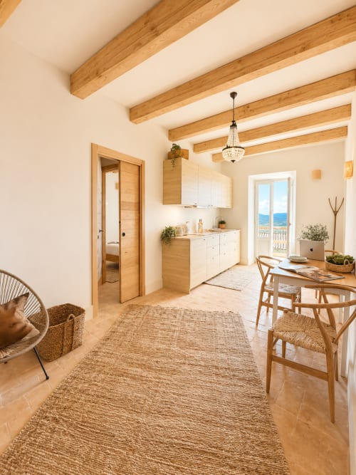 Bright Tuscan apartment with wooden beams, kitchenette, dining area, and garden view balcony
